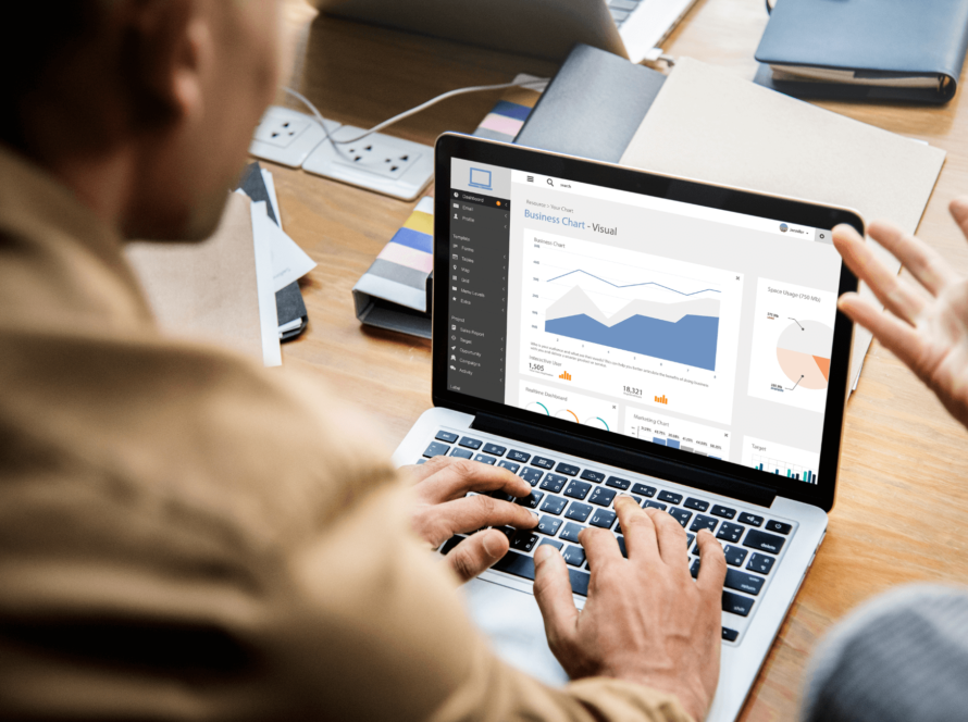 A person focused on a laptop displaying various graphs, indicating data analysis or business performance.